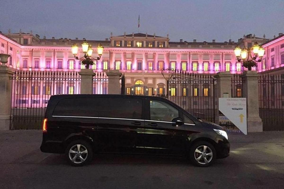 musta pakettiauto pysäköitynä vaaleanpunaisilla valoilla varustetun rakennuksen eteen