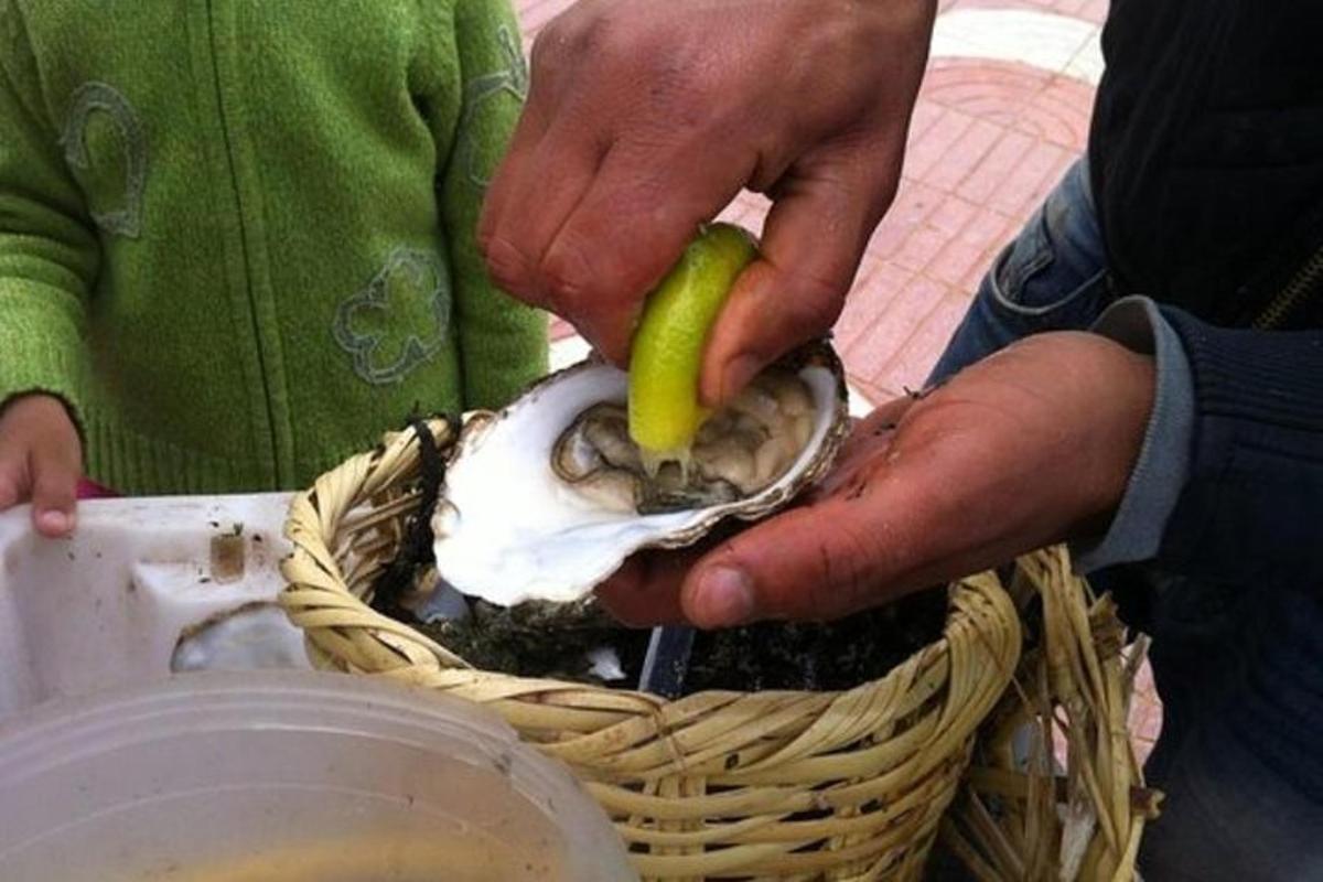 una persona che tiene in mano un'ostrica con un plettro dentro