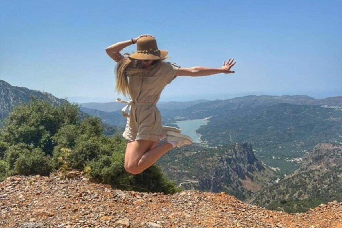 Μια γυναίκα πηδάει στον αέρα στην κορυφή ενός βουνού