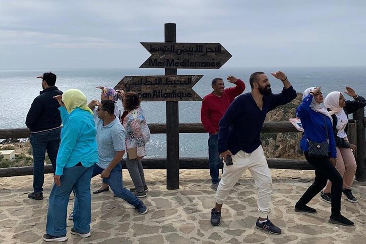 a group of people standing near the ocean