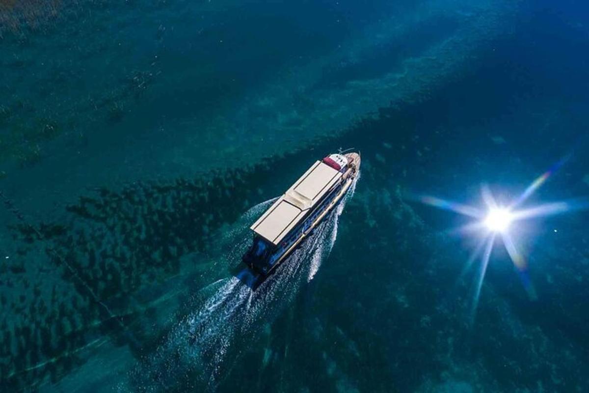 ein Boot, das im Meer schwimmt, während die Sonne scheint