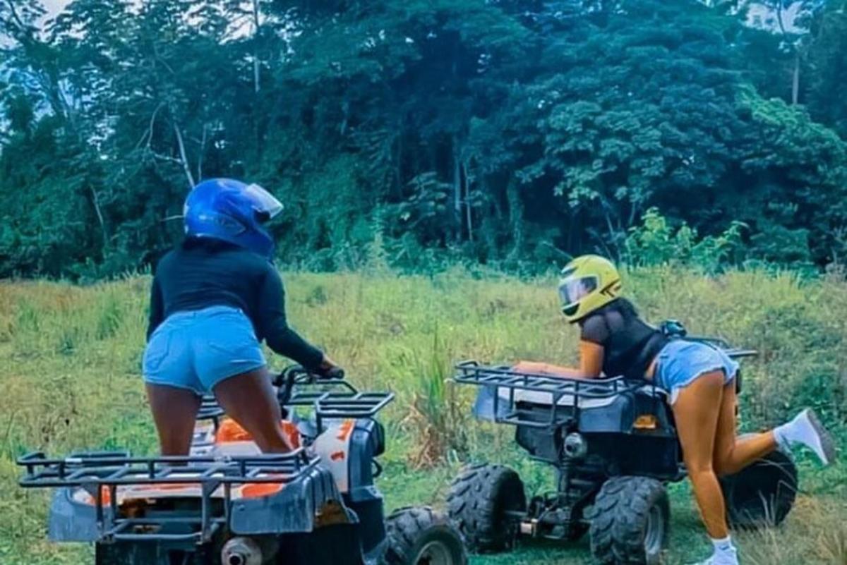Dos personas viajando en vehículos todo terreno en un campo