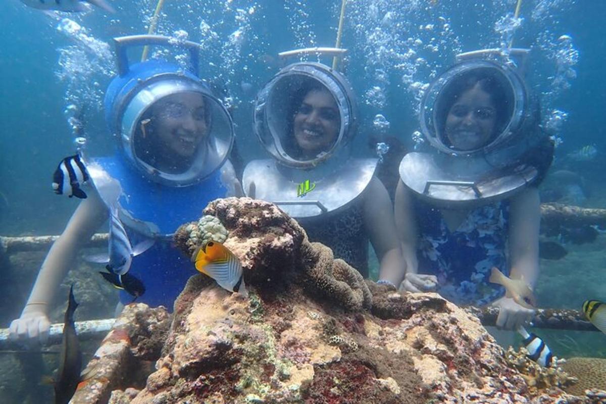 a group of three children wearing diving gear in the ocean