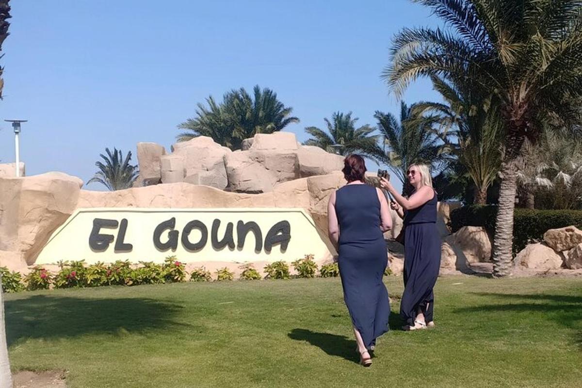 zwei Frauen gehen vor einem Schild in einem Resort