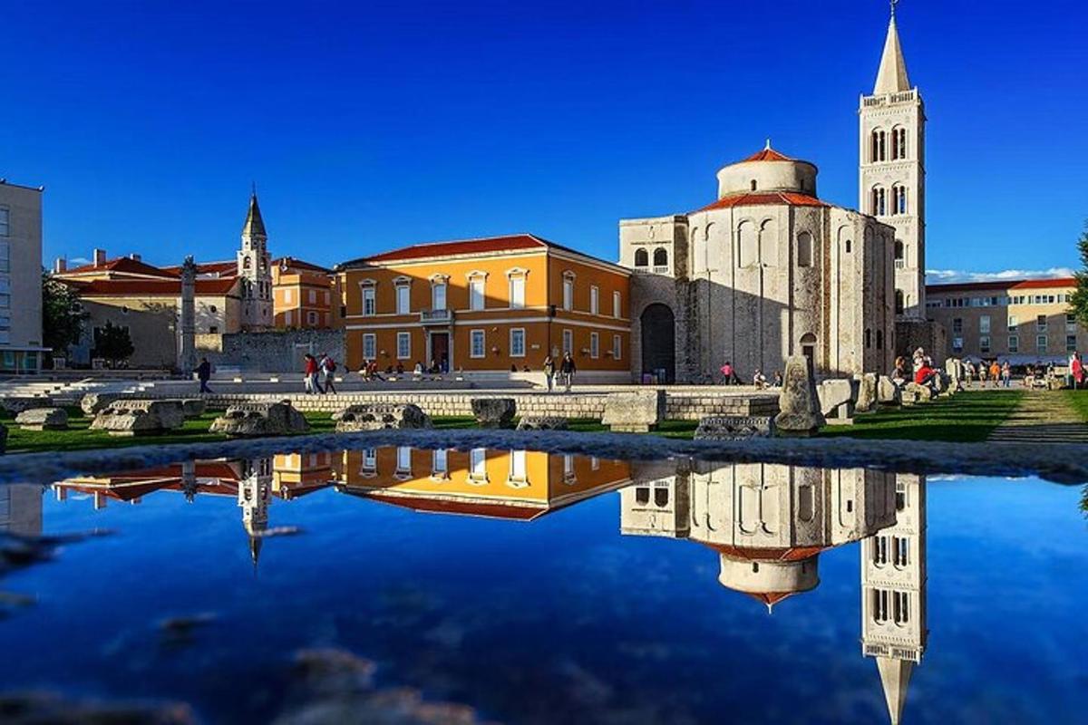 budova s hodinovou věží a odrazem ve vodě