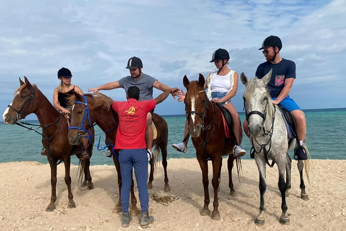 en gruppe mennesker som rir på hester på stranden