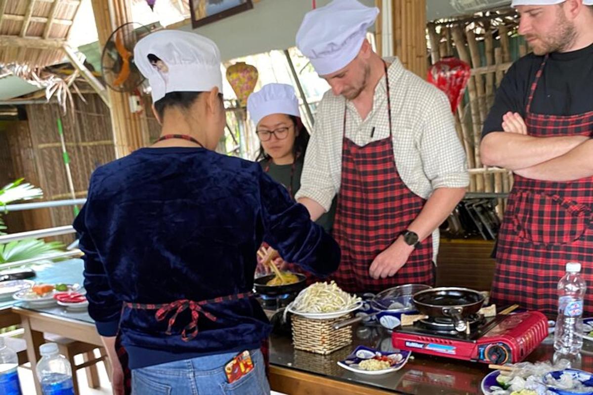 skupina ljudi v kuhinji, ki pripravlja hrano