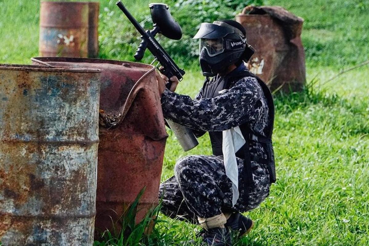 a man wearing a gas mask sitting next to a trash can