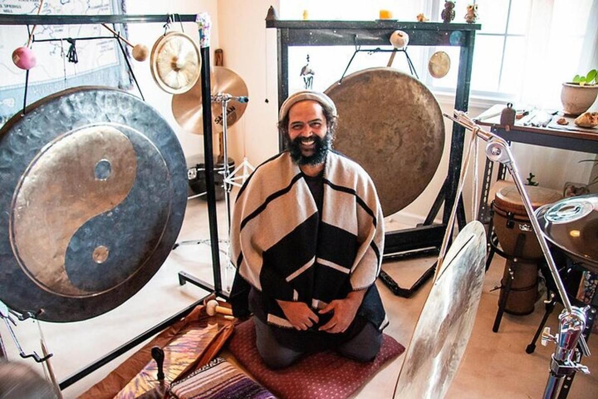 a man sitting on a chair in a room with gongs