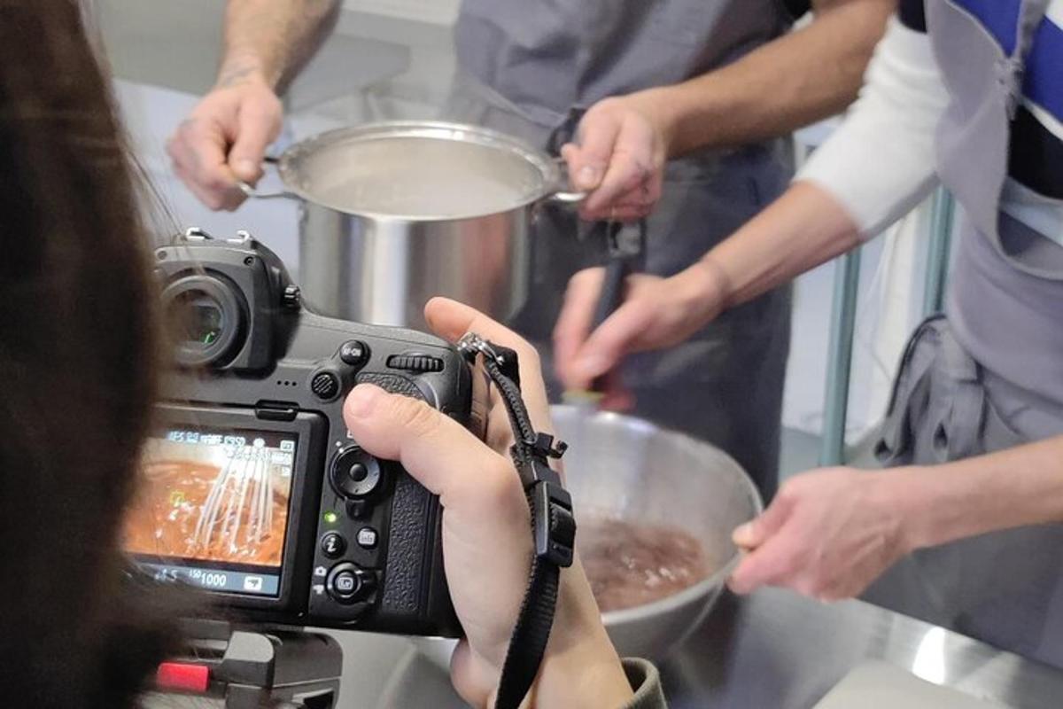 seseorang yang mengambil gambar dengan kamera di dapur