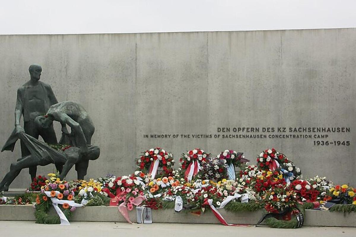 um monumento com flores em frente a uma estátua