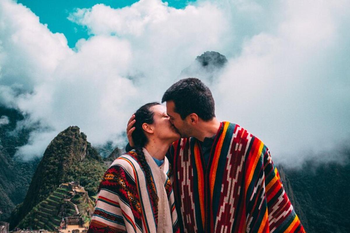 um homem e uma mulher se beijando em frente a uma montanha