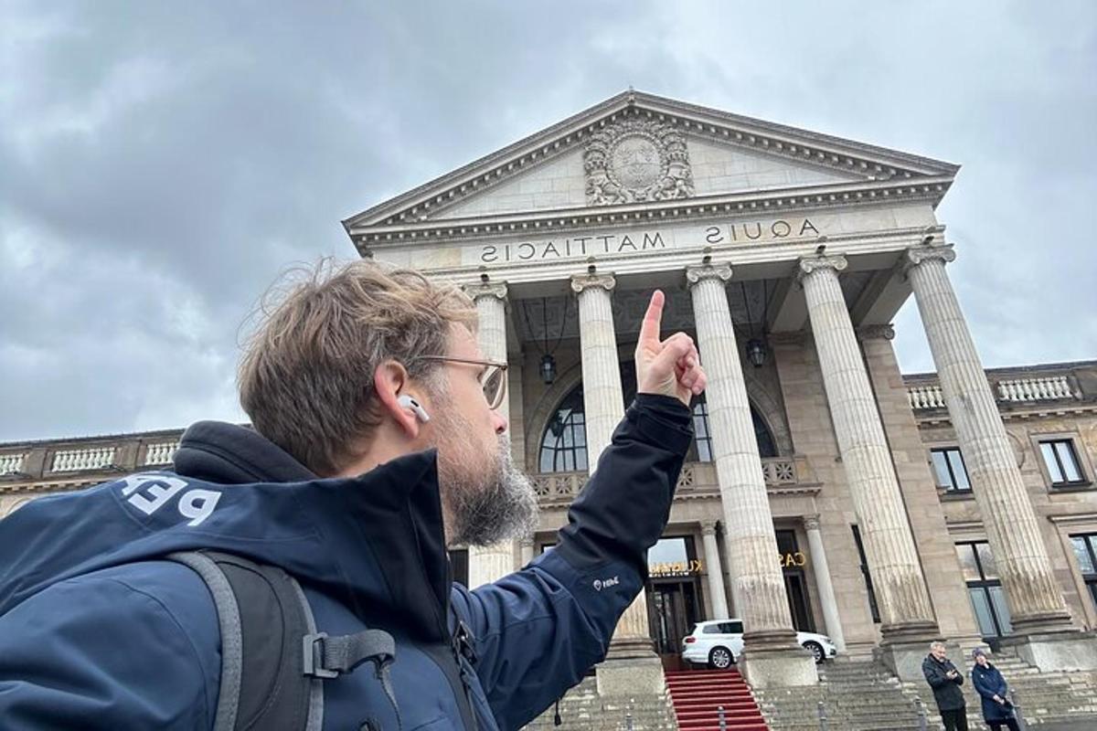 muž dává znamení míru před budovou