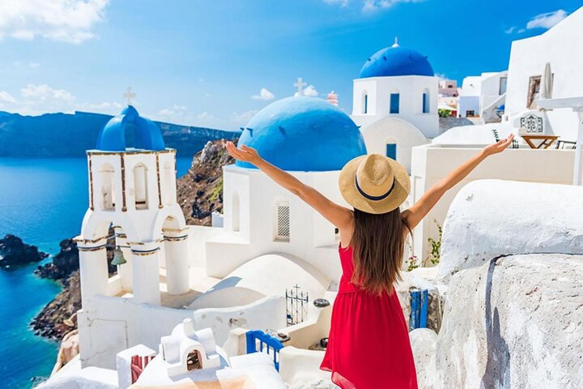 Žena v klobouku si prohlíží památky Santorini