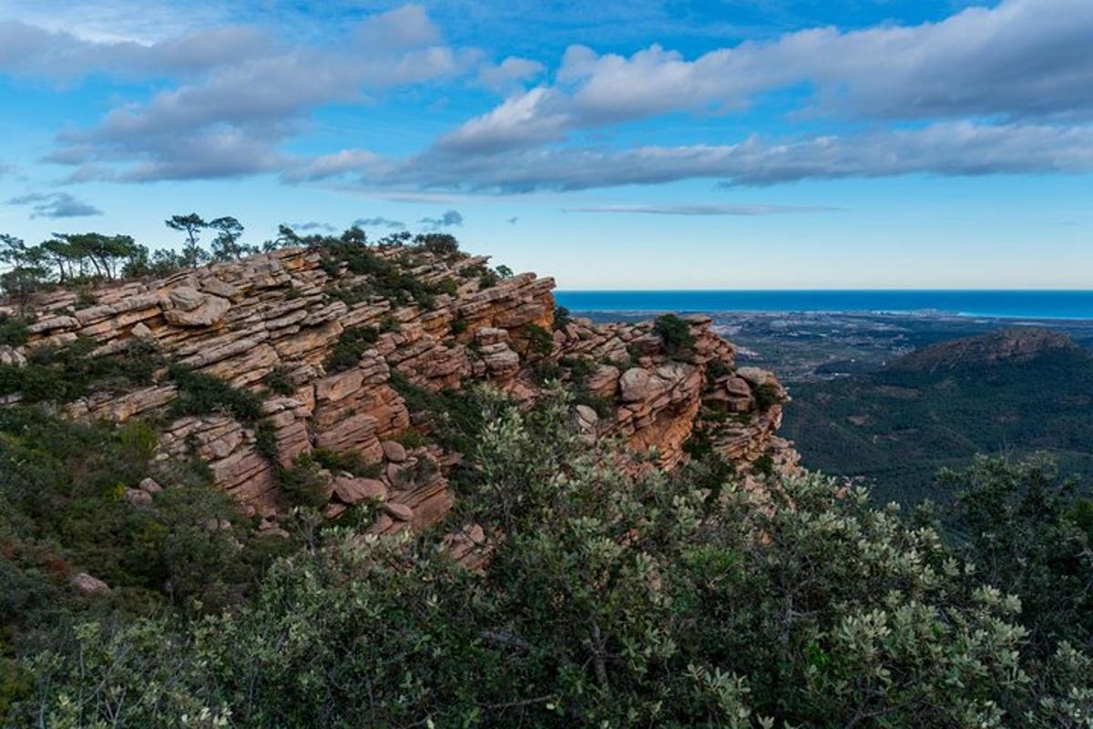 a rocky mountain with the ocean in the background