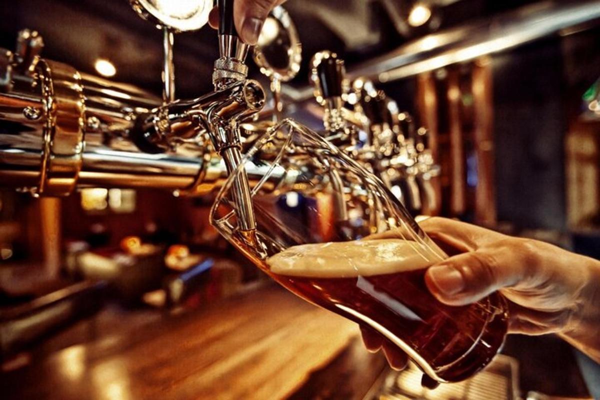 una persona está bebiendo un vaso de cerveza