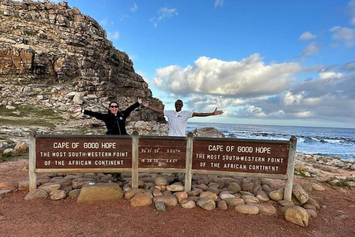 Dos hombres de pie sobre un cartel en la playa