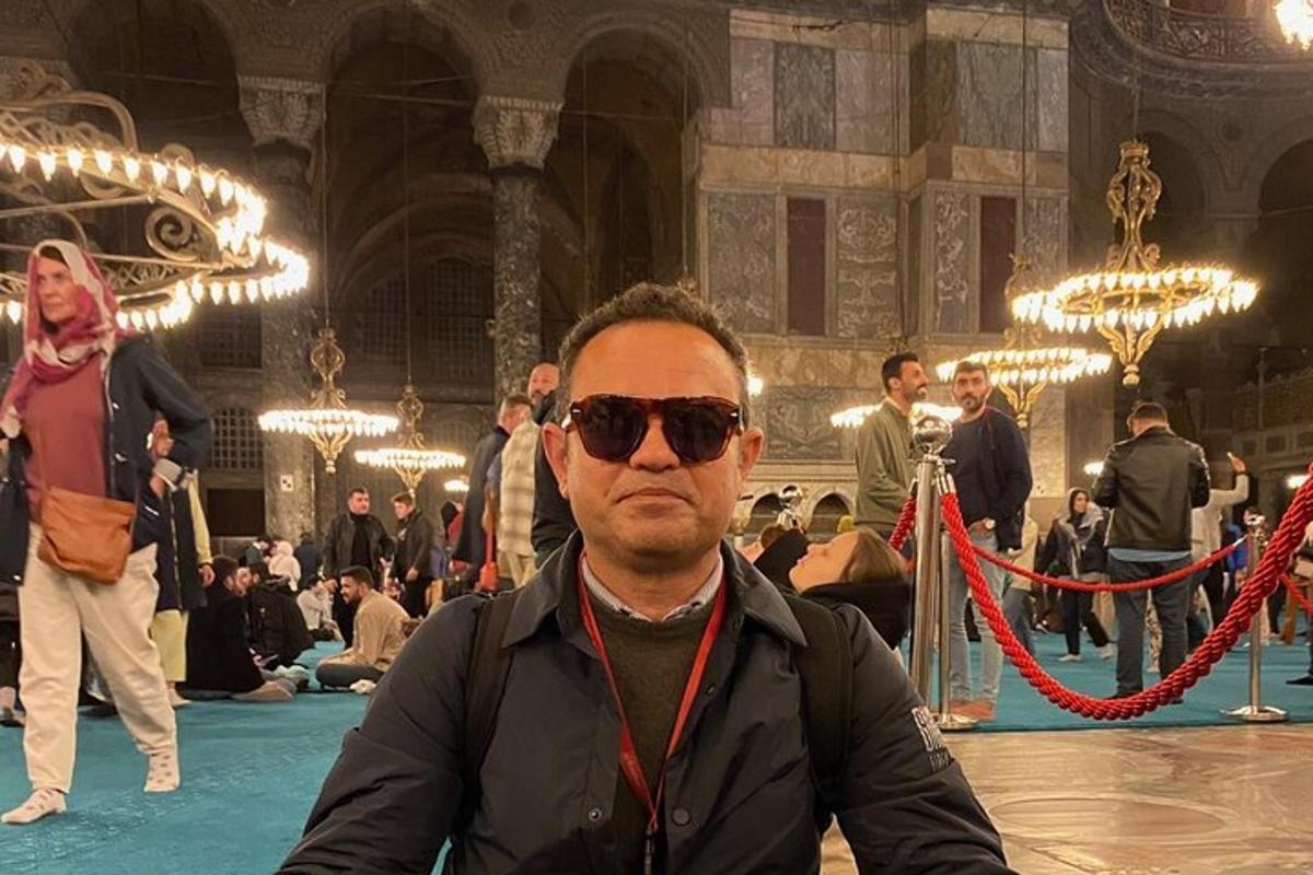 muž so slnečnými okuliarmi sediaci za stolom v budove