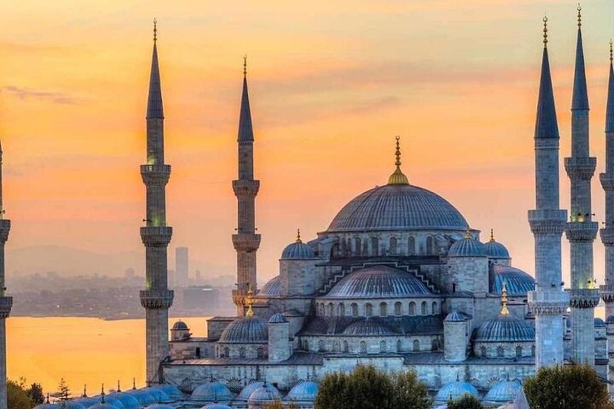 a blue mosque with blue domes and minarets at sunset