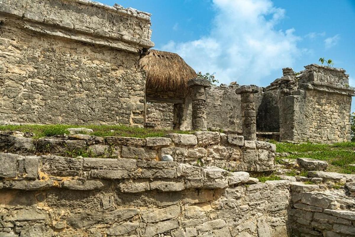 an old stone building with a straw roof