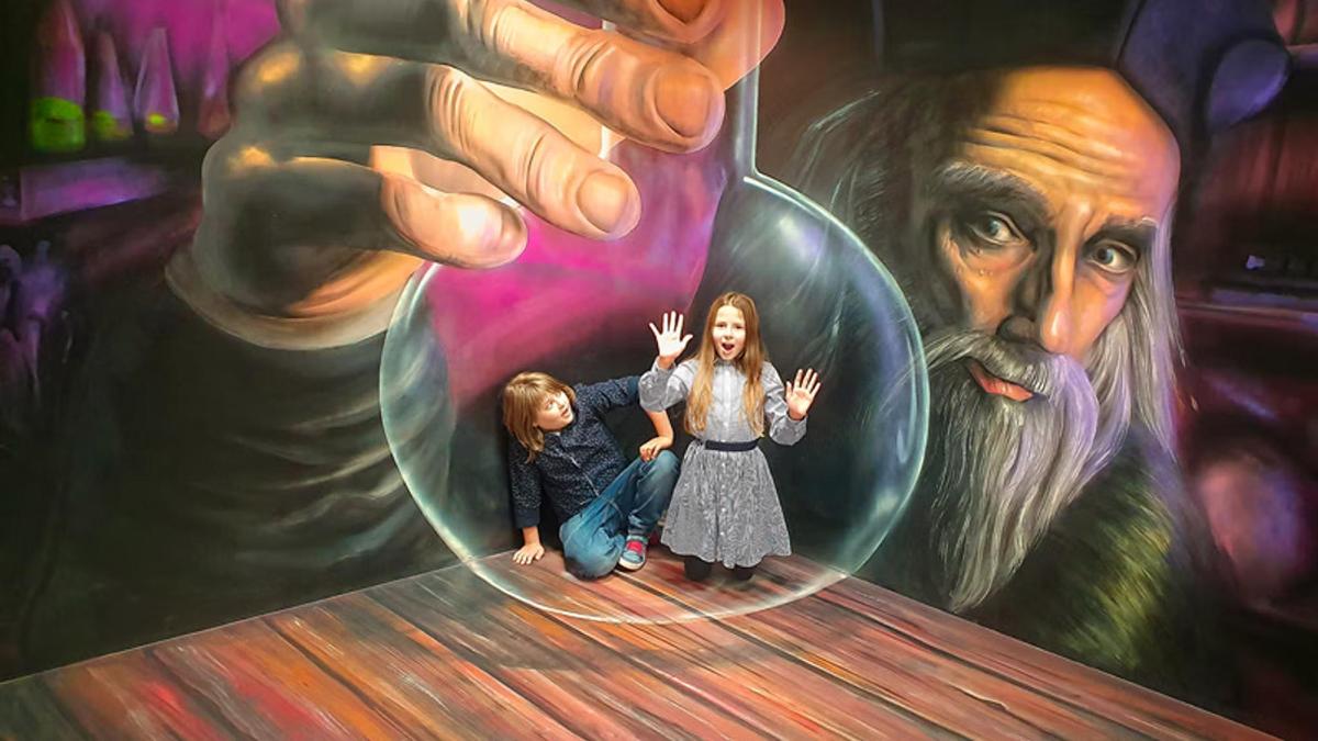 two girls standing in front of a mural of a hand