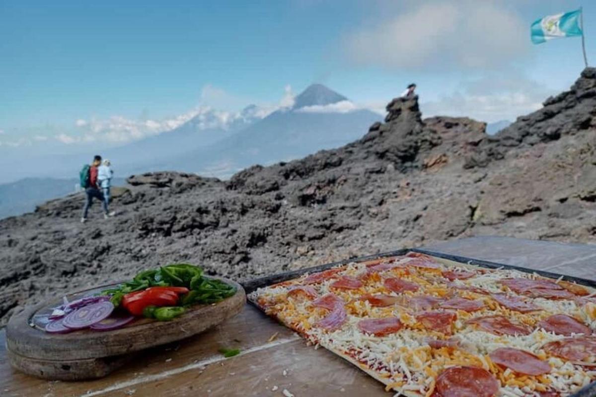 a pizza and vegetables on a table on a mountain