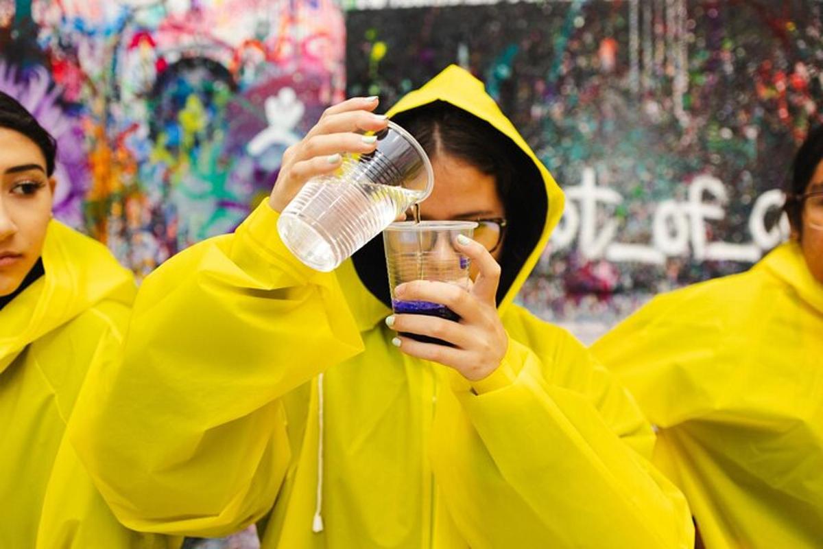 dvě ženy ve žlutých pláštěnkách držící drink