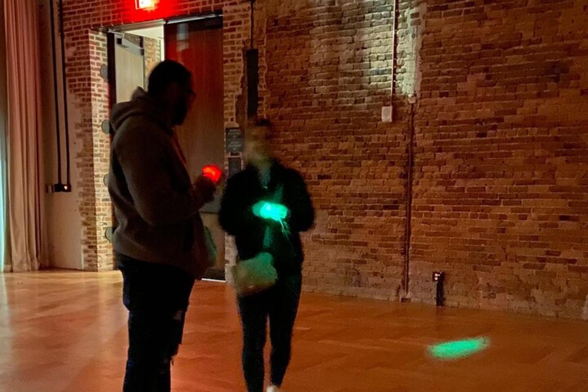 two people walking in a room with neon lights