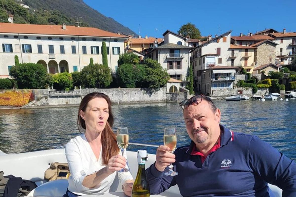 en mann og en kvinne som sitter på en båt og holder champagneglass