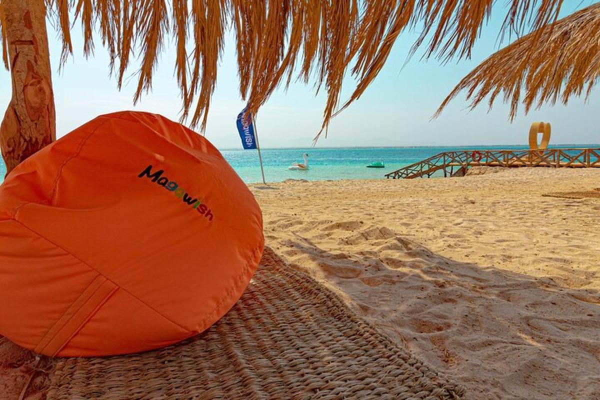 Una sombrilla naranja en una playa de arena