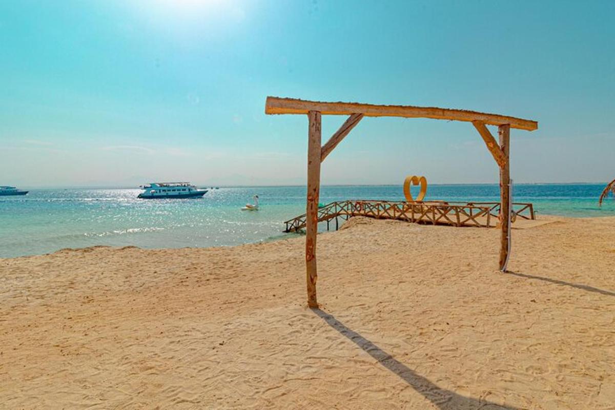 Una estructura de madera en una playa con un barco en el agua.