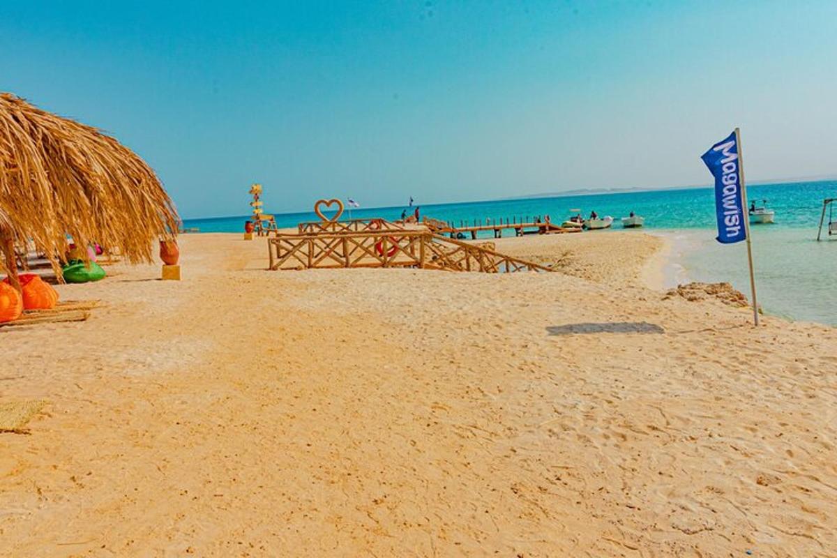pantai dengan bangku dan bendera di atas pasir