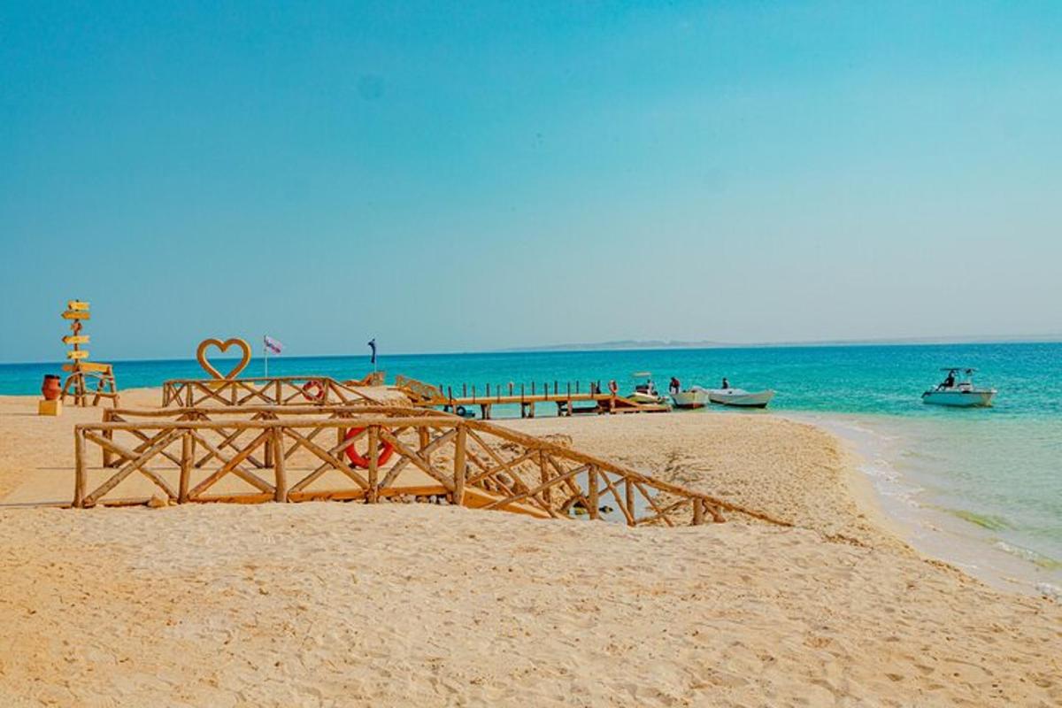 Una cama de madera en una playa de arena junto al océano.