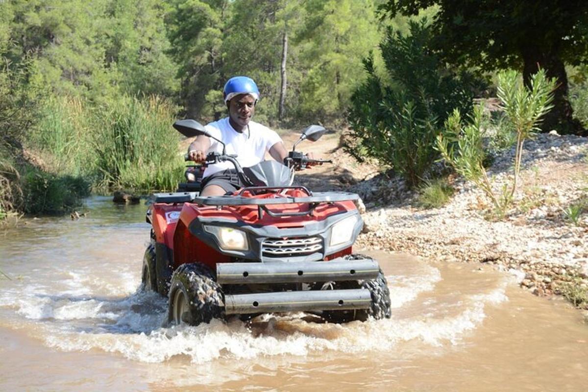 un uomo che attraversa un fiume su un quad