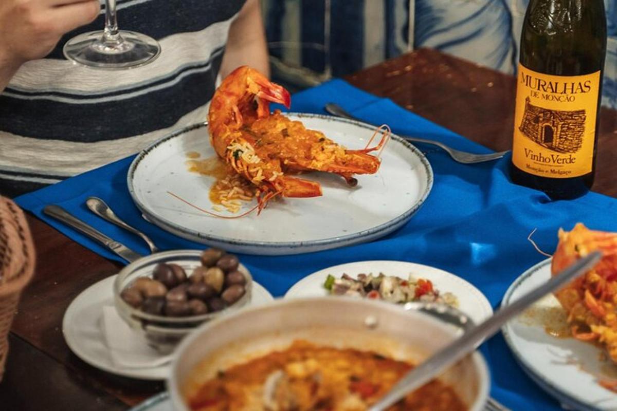 una taula amb plats de menjar i una ampolla de vi