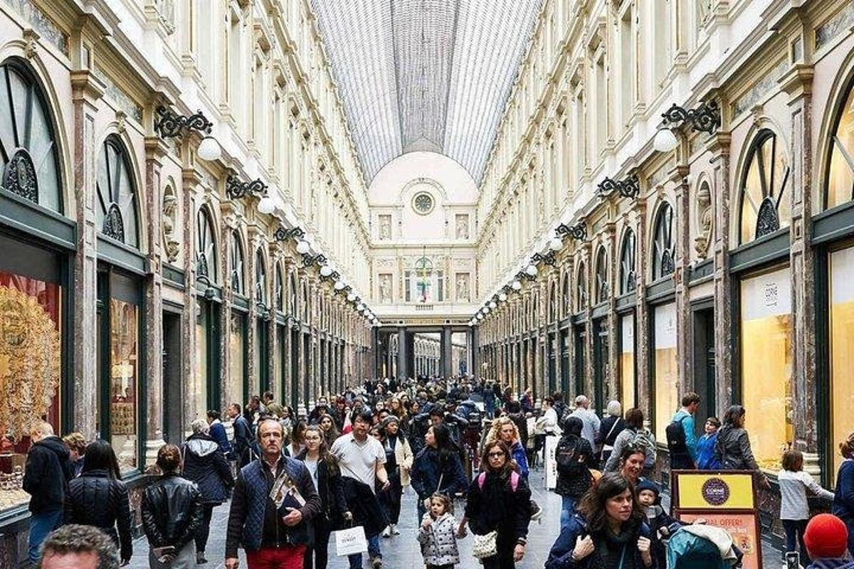 a crowd of people walking through a shopping mall