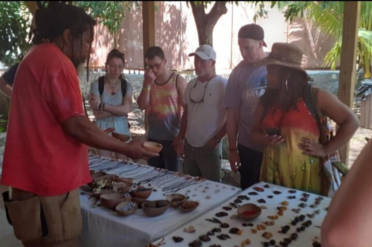um grupo de pessoas em pé ao redor de uma mesa com cupcakes