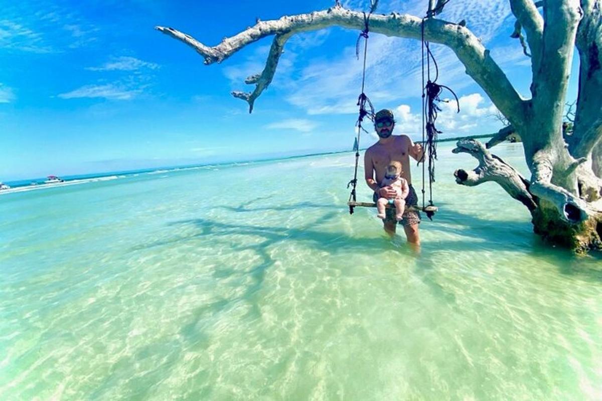 een man op een schommel in het water op een strand