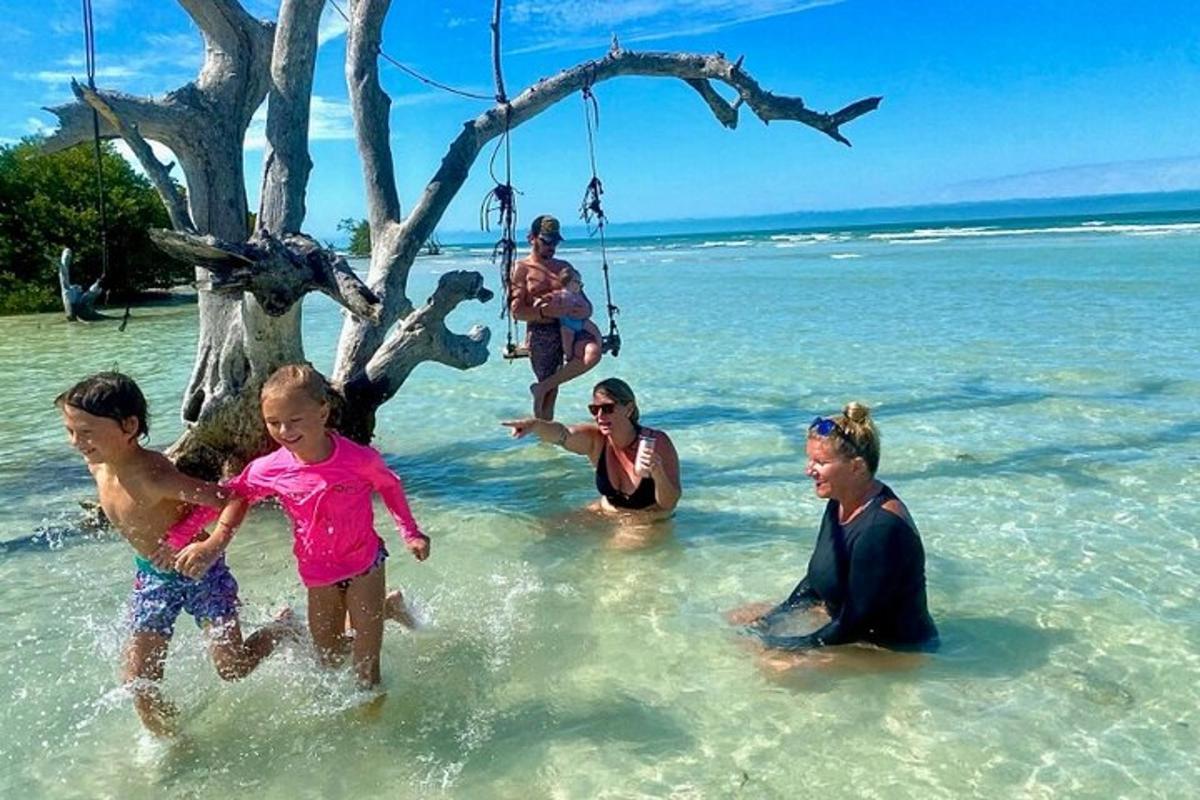 een groep mensen die in het water op het strand spelen