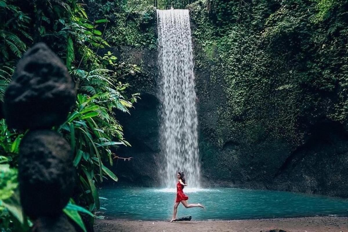 eine Frau, die vor einem Wasserfall rennt