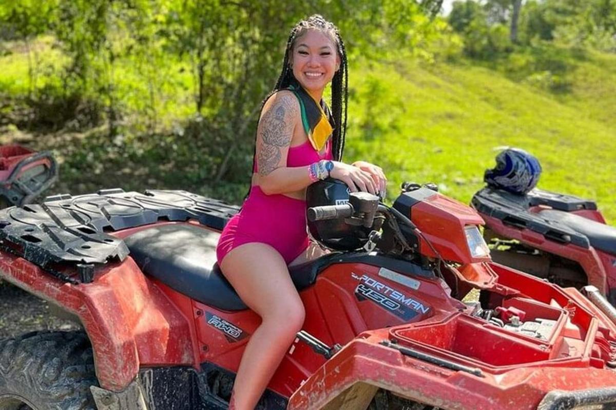 žena v růžových šatech sedící na čtyřkolce