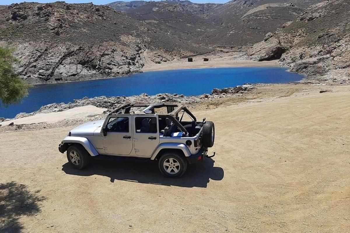 una jeep bianca parcheggiata su una strada sterrata accanto a un lago