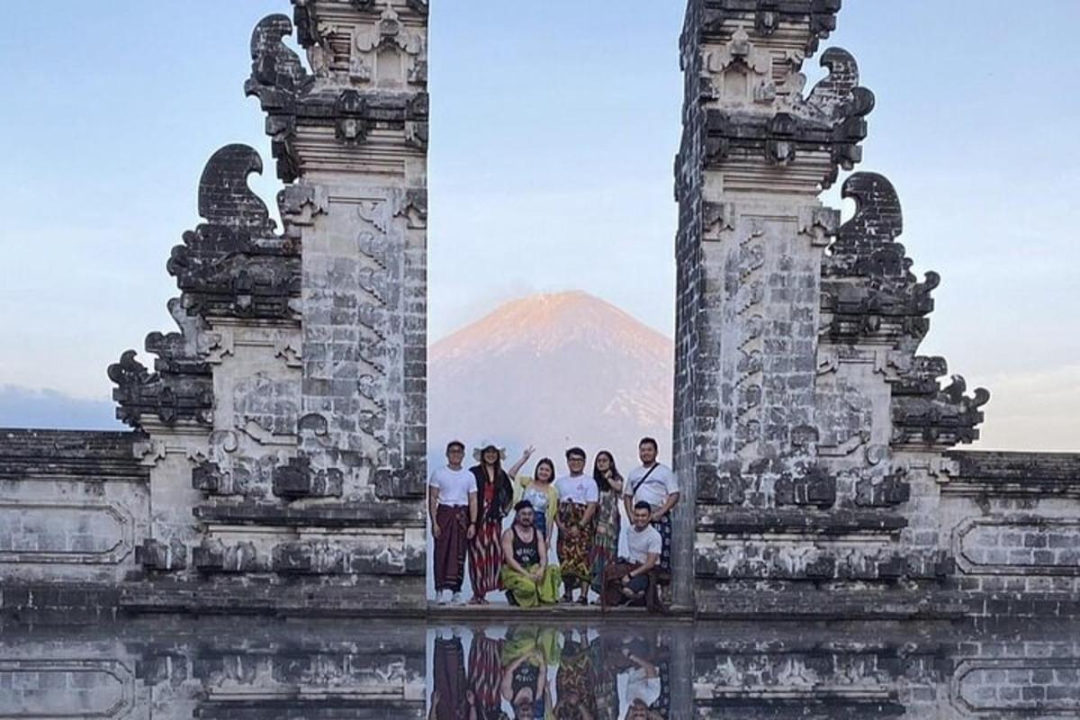 Un grupo de personas de pie en un edificio con una montaña al fondo.