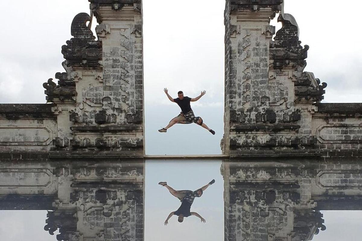 Un hombre saltando al agua frente a un edificio antiguo.