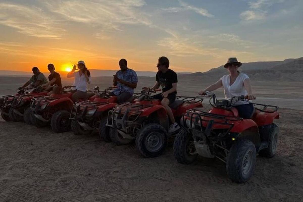 un gruppo di persone sedute su quad nel deserto