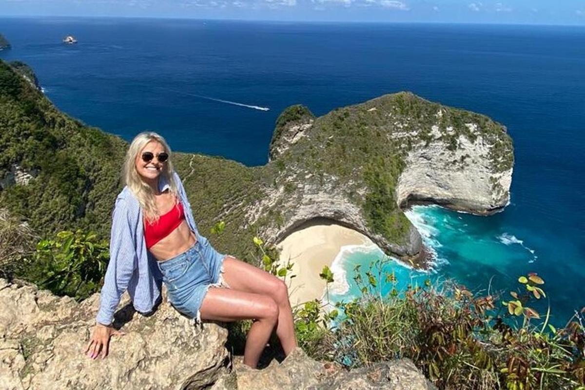 žena sedící na skále poblíž oceánu