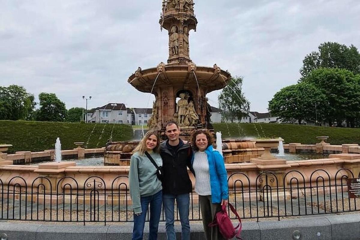 um grupo de pessoas em pé em frente a uma fonte