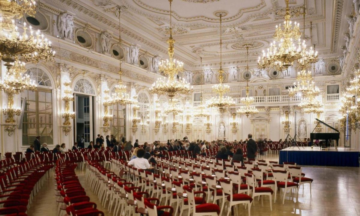 didelis kambarys, pilnas kėdžių ir šviestuvų