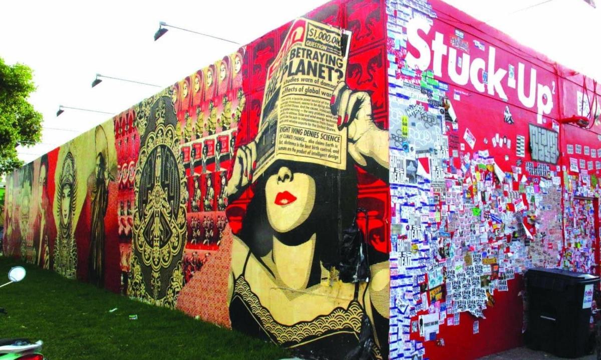 un muro con un dipinto di una donna che tiene in mano un libro