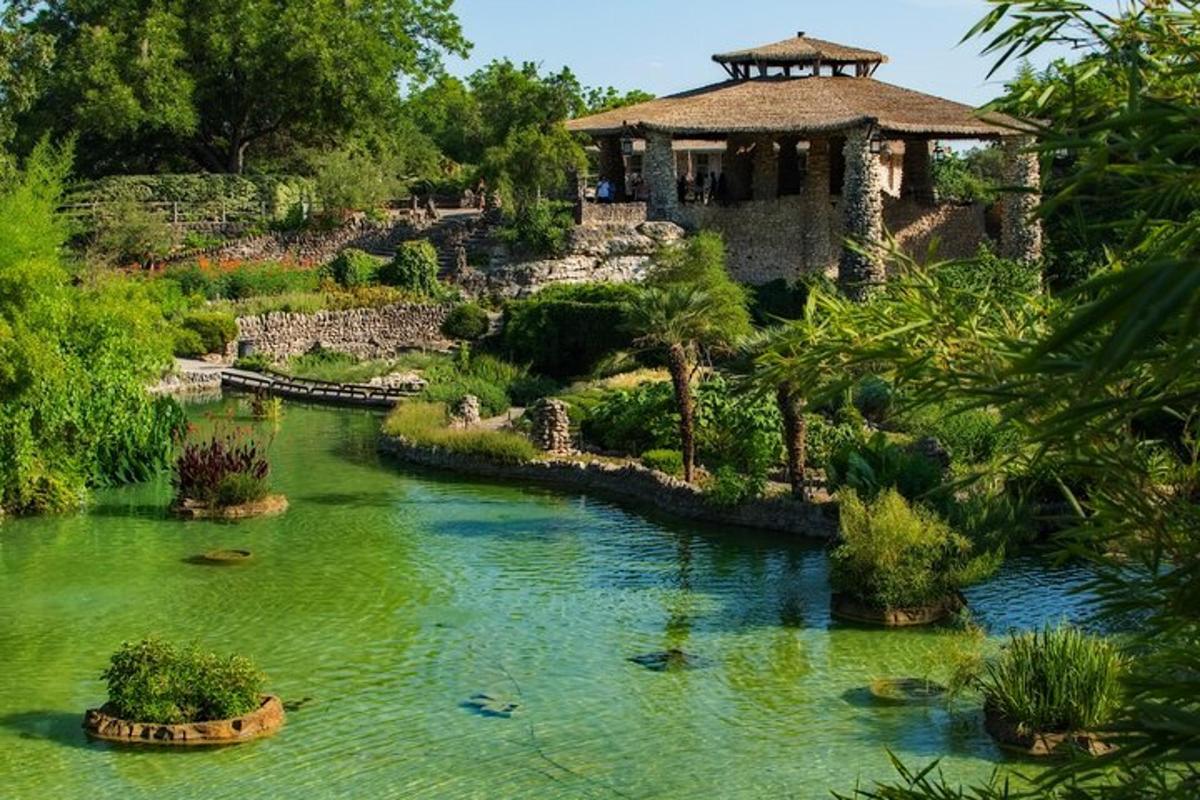 a garden with a pond in front of a building